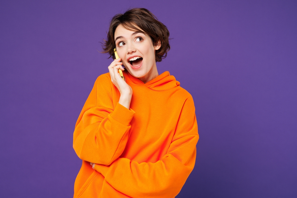 young,shocked,surprised,happy,woman,she,wear,orange,hoody,casual